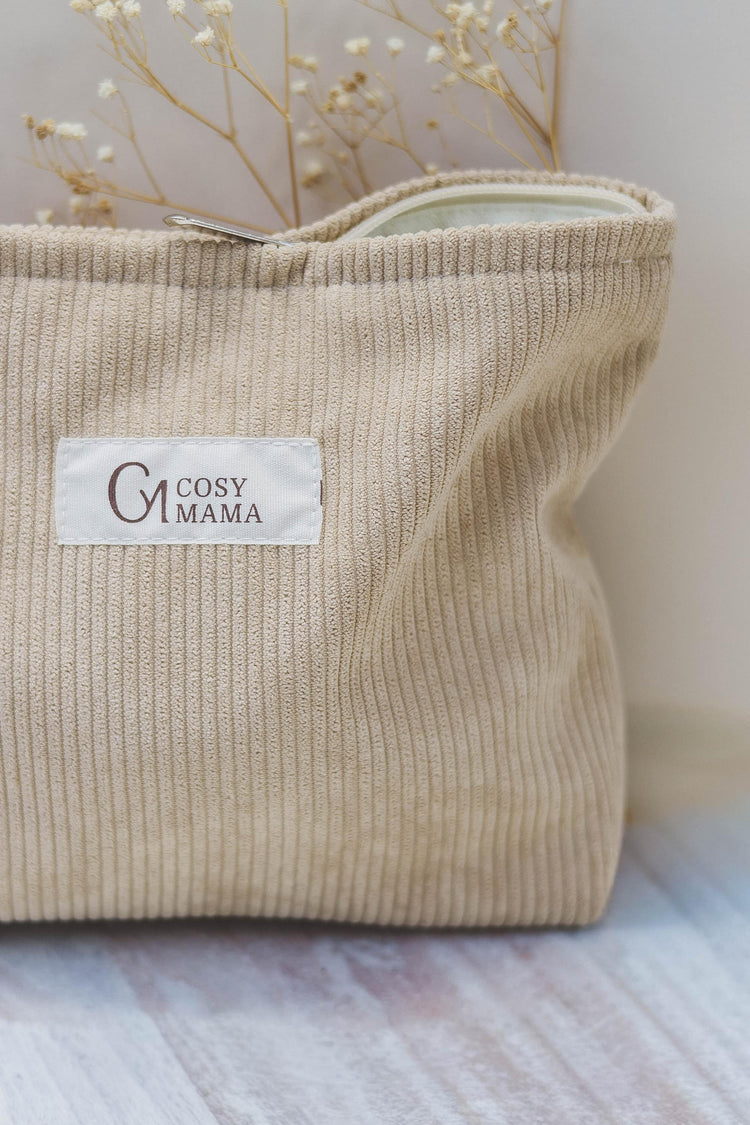 Beige carry bag with logo Cosy Mama sewn onto it. Zip is half open. Can be used to carry birth essentials