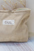 Beige carry bag with logo Cosy Mama sewn onto it. Zip is half open. Can be used to carry birth essentials