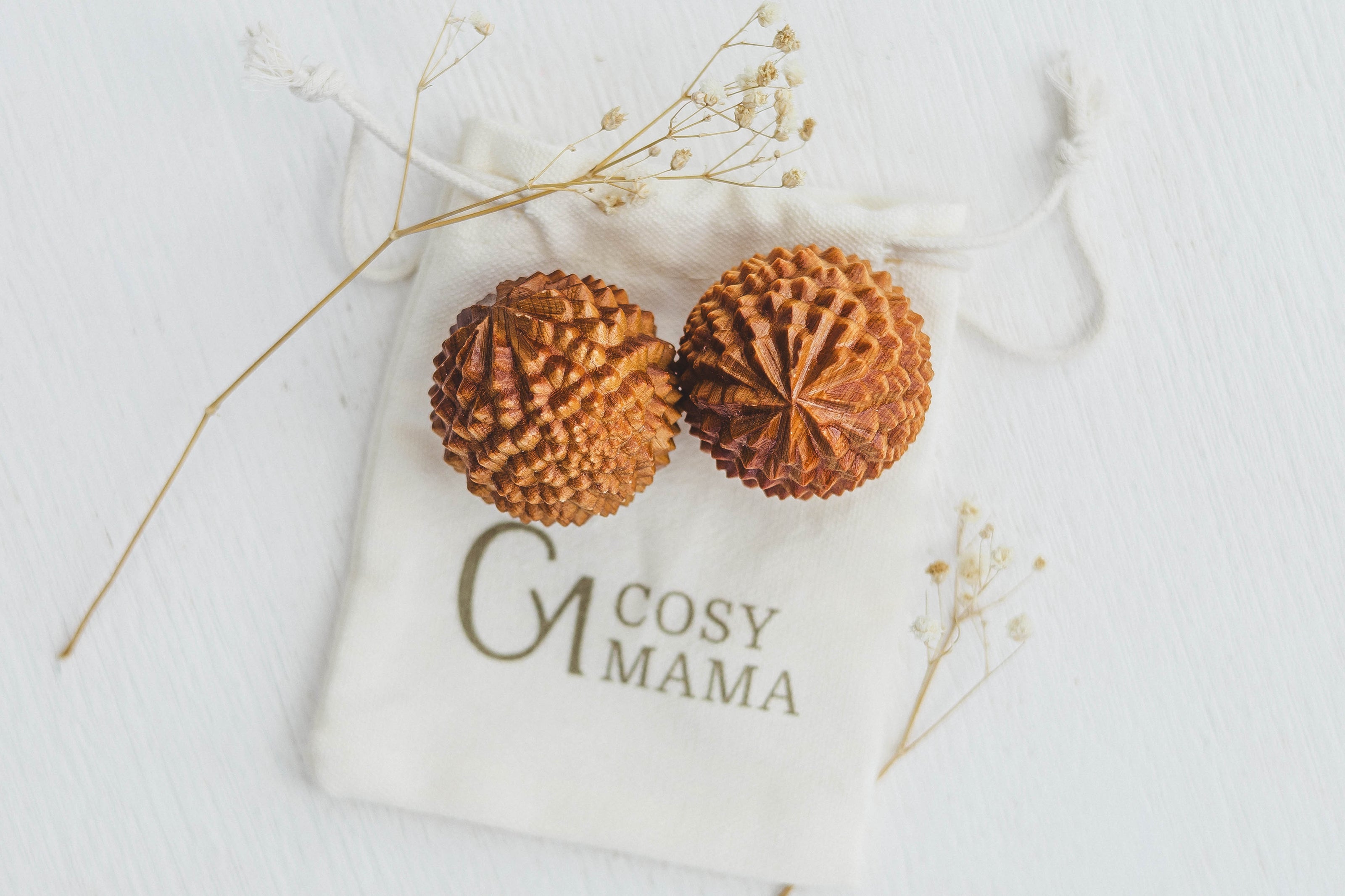 Cosy Mama Birth Orbs on a white labelled pouch with dried flowers around