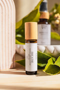 A small amber glass roll-on bottle. The bottle has a white label reading 'BREATHE' by Cosy Mama