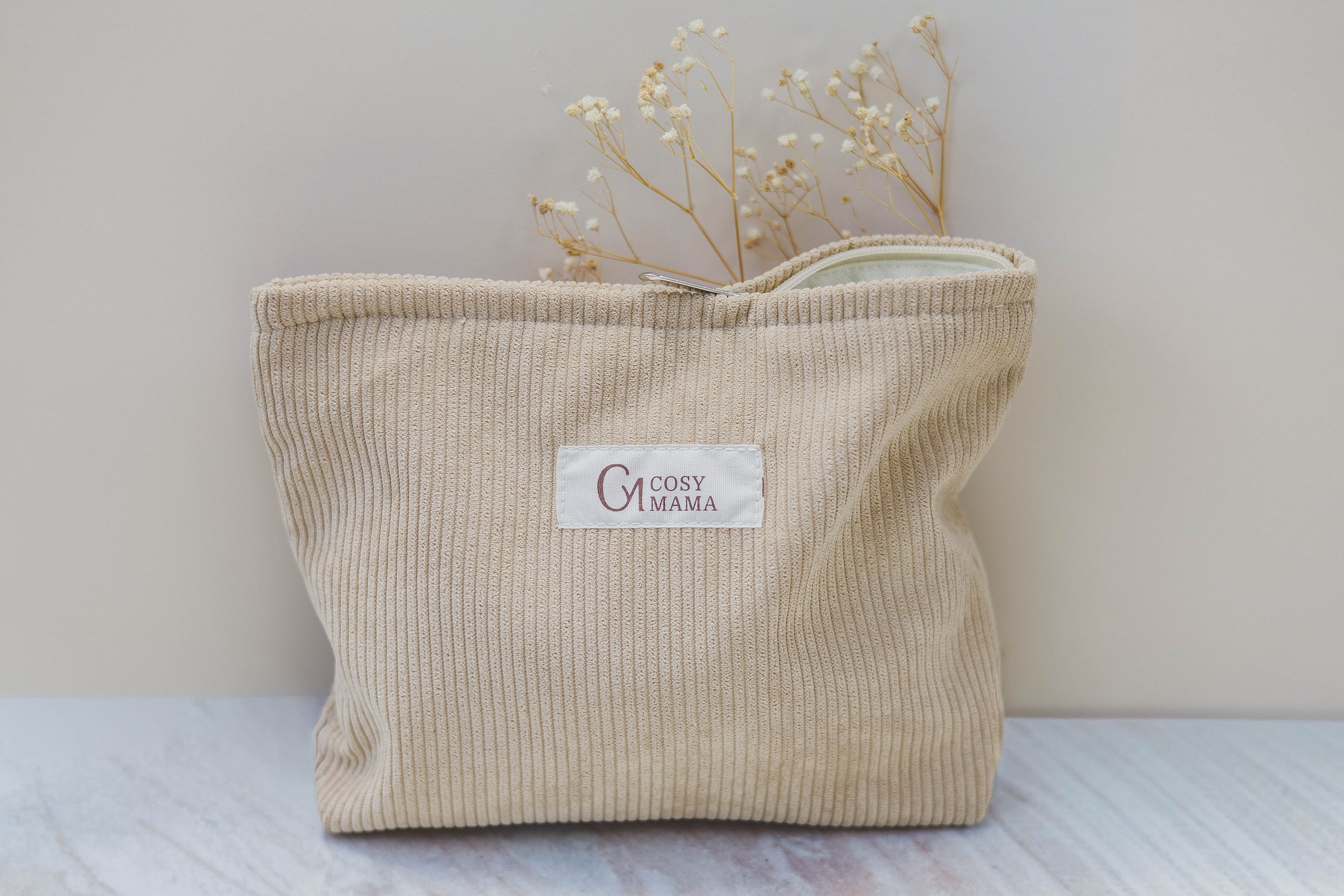 Beige corduroy bag with 'Cosy Mama' label on a light background