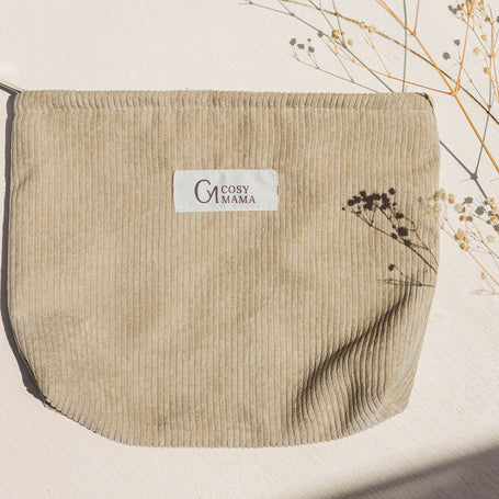 Beige pouch with Cosy Mama brand label on a light background