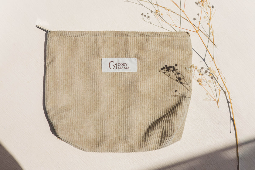 Beige pouch with Cosy Mama brand label on a light background