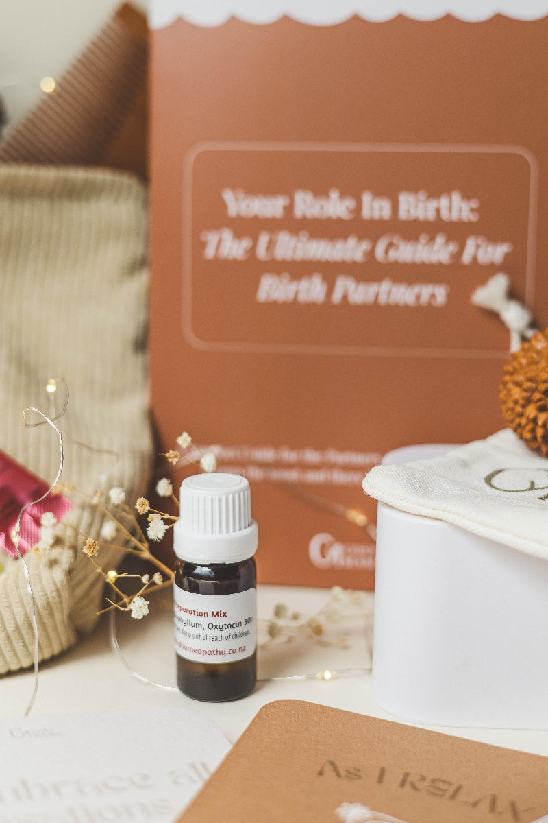 Small 10ml birth remedy mix on a surface with a book titled 'Your Role in Birth' in the background.