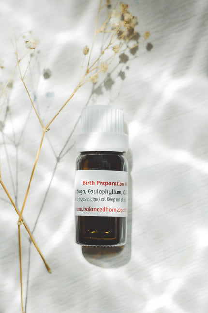 Small bottle labeled 'Birth Preparation Mix' on a white background with dried plants.