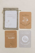 Set of four birth affirmation cards with text and illustrations on a beige background